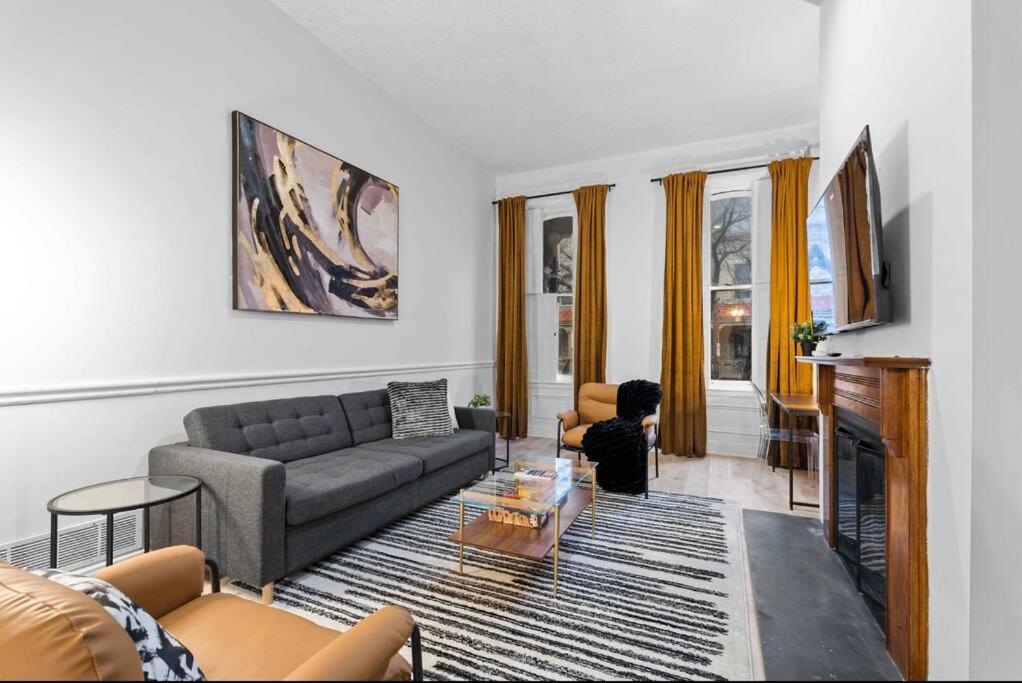 a living room with a couch and a fireplace at Northside Pittsburgh Luxurious Apartment in Pittsburgh