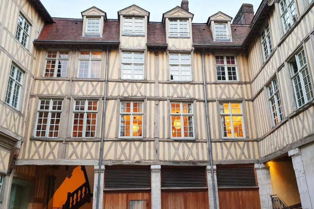 un vieux bâtiment avec de nombreuses fenêtres sur une rue dans l'établissement Hôtel Turgot - Ancien hôtel particulier - Lumineux, à Rouen