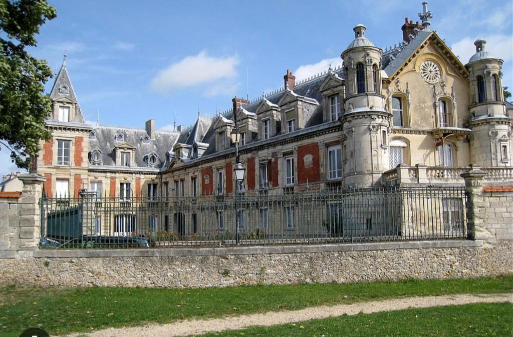 ein großes Haus mit einem Zaun davor in der Unterkunft Charmante maison à 30 minutes de # Paris in Conflans-Sainte-Honorine