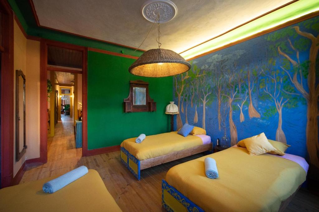 a bedroom with two beds and a mural of trees at Soul - moradia criativa in Vila Franca de Xira