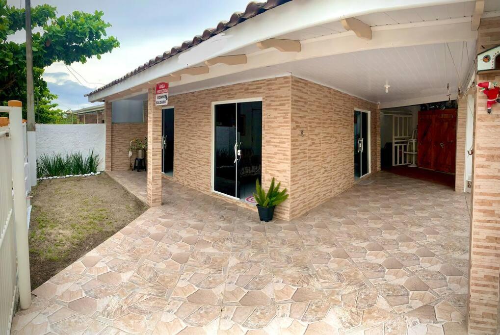 ein Haus mit einer Terrasse davor in der Unterkunft Refúgio perto do Mar: Ótima casa a 350m da praia in Pontal do Paraná