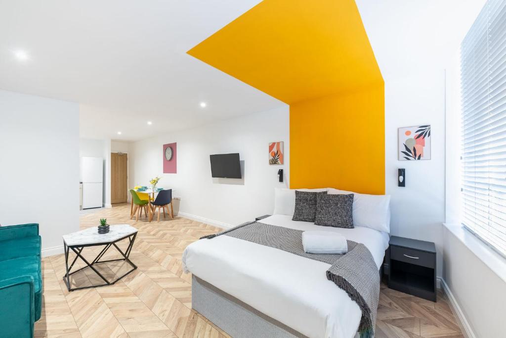 樸次茅斯的住宿－Paradise Suite，一间卧室设有一张床和黄色的墙壁