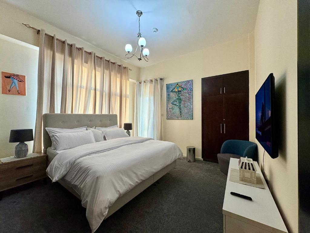 Dormitorio con cama, escritorio y TV en Master Room, en Dubái