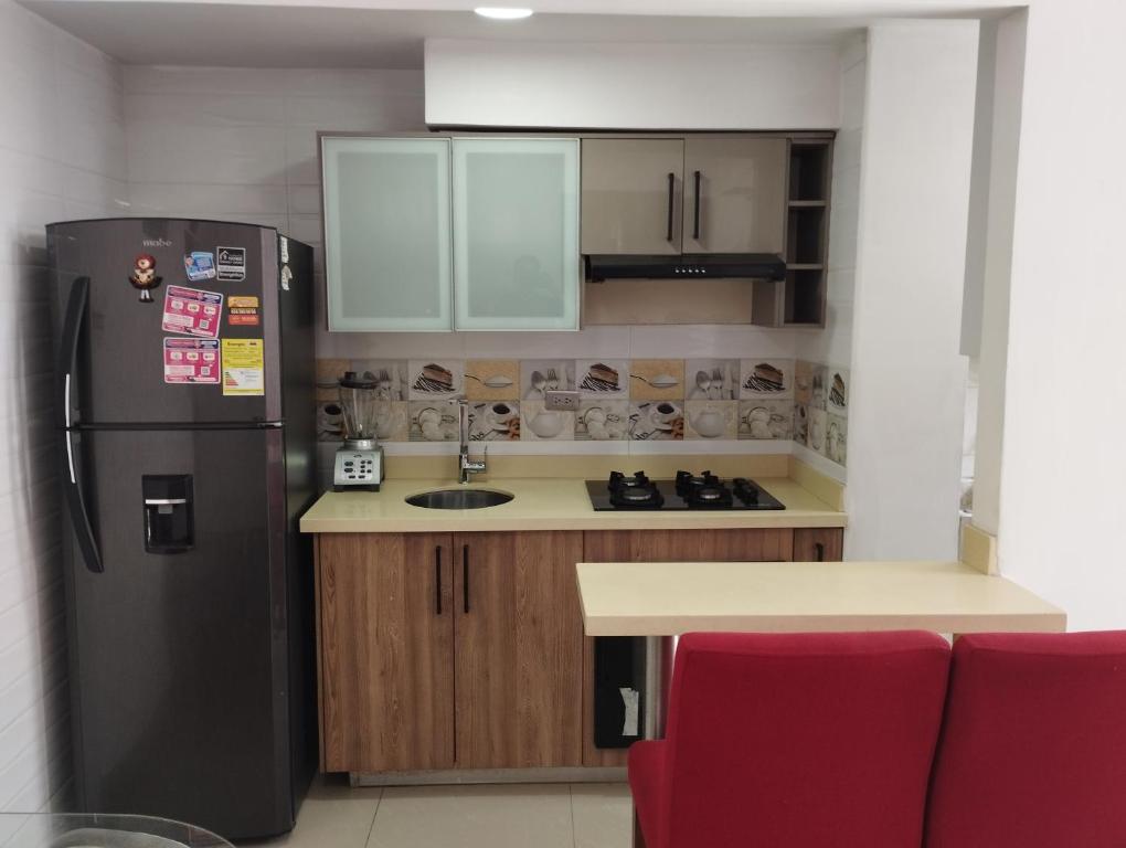 eine Küche mit einem schwarzen Kühlschrank und einer Theke in der Unterkunft apartamento cerca al aeropuerto parqueadero privado conjunto cerrado bilbao in Cúcuta