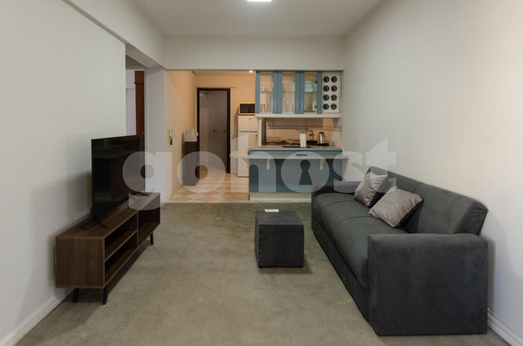 a living room with a couch and a kitchen at Amazing Apartment Near La Costanera in Asuncion