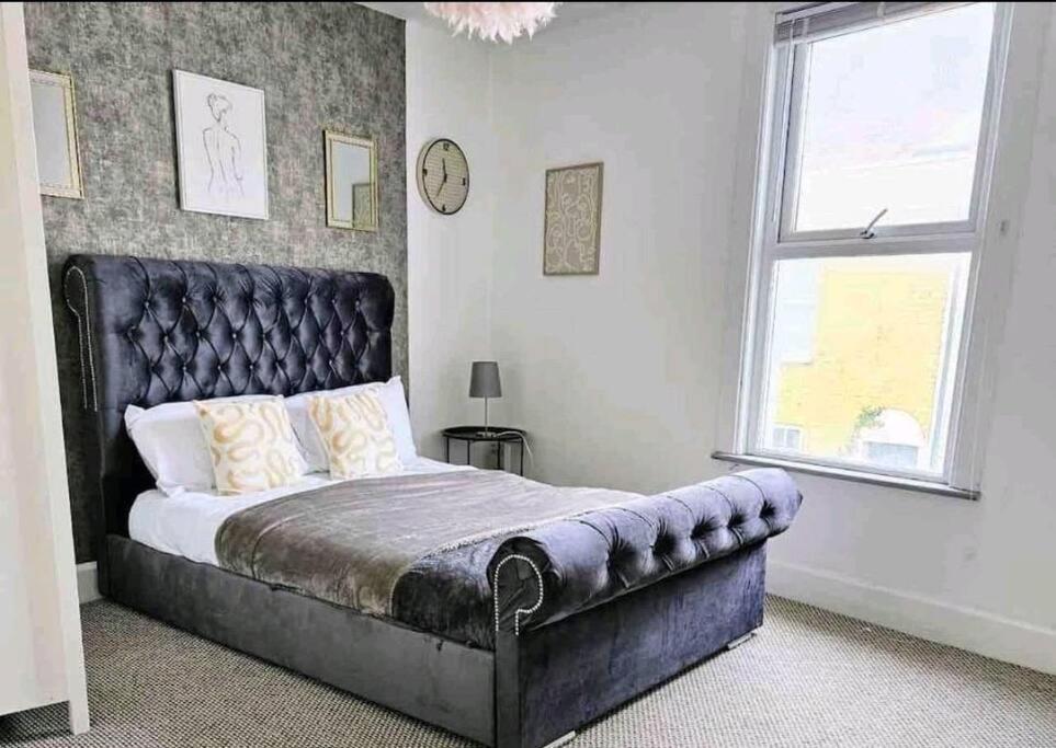 a bedroom with a large bed with a leather headboard at King Charles House in Gillingham