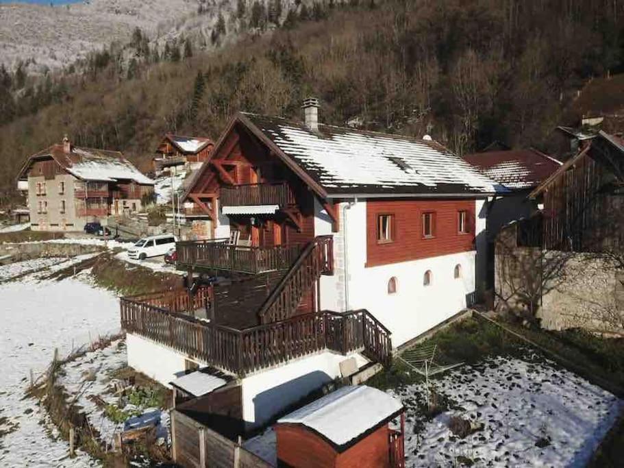 una casa roja y blanca con nieve en el techo en Charme des montagnes et Annecy, en Thônes