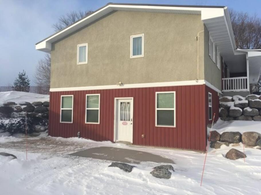 una casa con una porta rossa nella neve di Country Basement Apartment (lower duplex) a Henderson