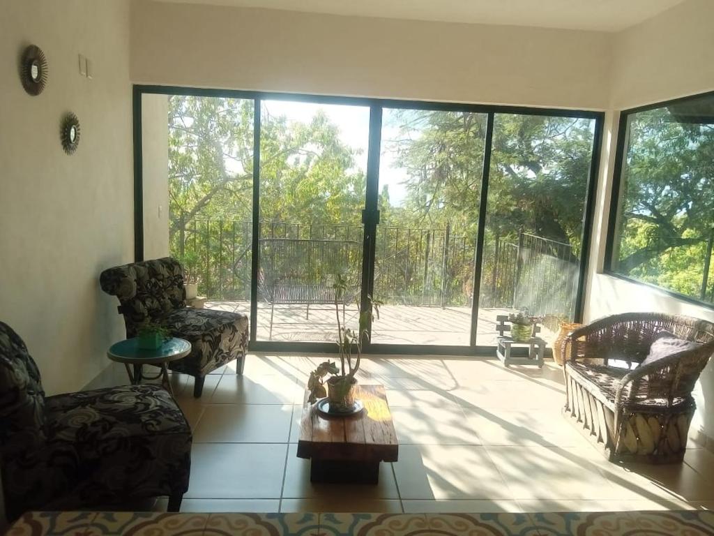 ein Wohnzimmer mit einer großen Glasschiebetür in der Unterkunft casa tranquila in Santo Domingo Ocotitlán