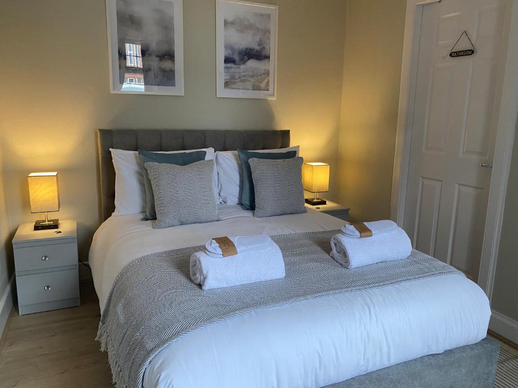 a bedroom with a bed with two towels on it at Peacock Guest House in Largs