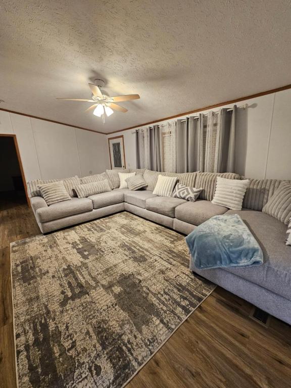 een woonkamer met een bank en een plafondventilator bij Camp Joy Lake House, Caldwell, TX sleeps 10 in Caldwell