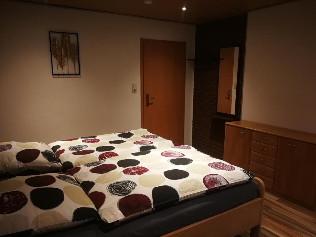 ein Schlafzimmer mit einem Bett mit einer Polka-Punktdecke in der Unterkunft Ferienwohnung mit Balkon 1.OG in Neustadt bei Coburg