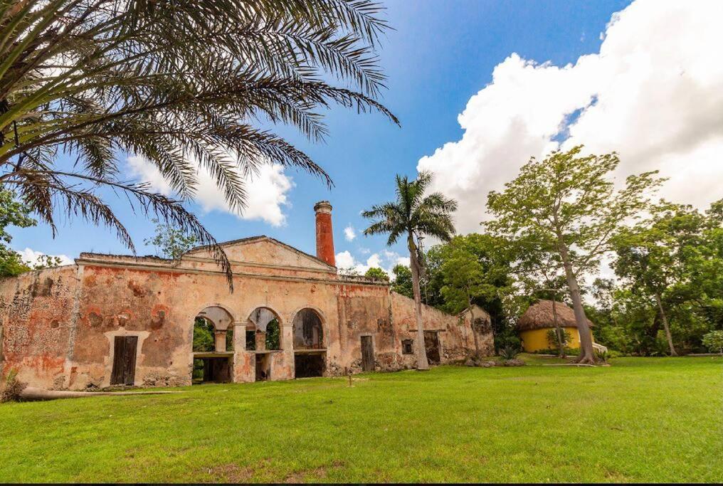 an old brick building with a chimney on a field at Spectacular Hacienda Henequenera with Cenote 
