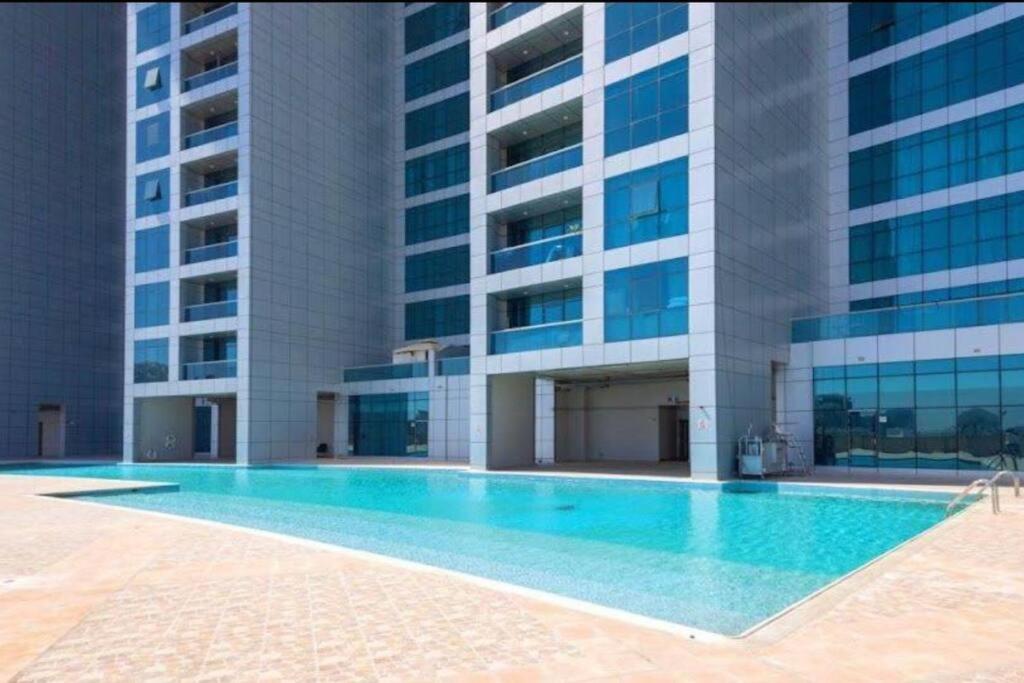 a swimming pool in front of a building at Amazing Beachfront Holiday Home in Ajman 