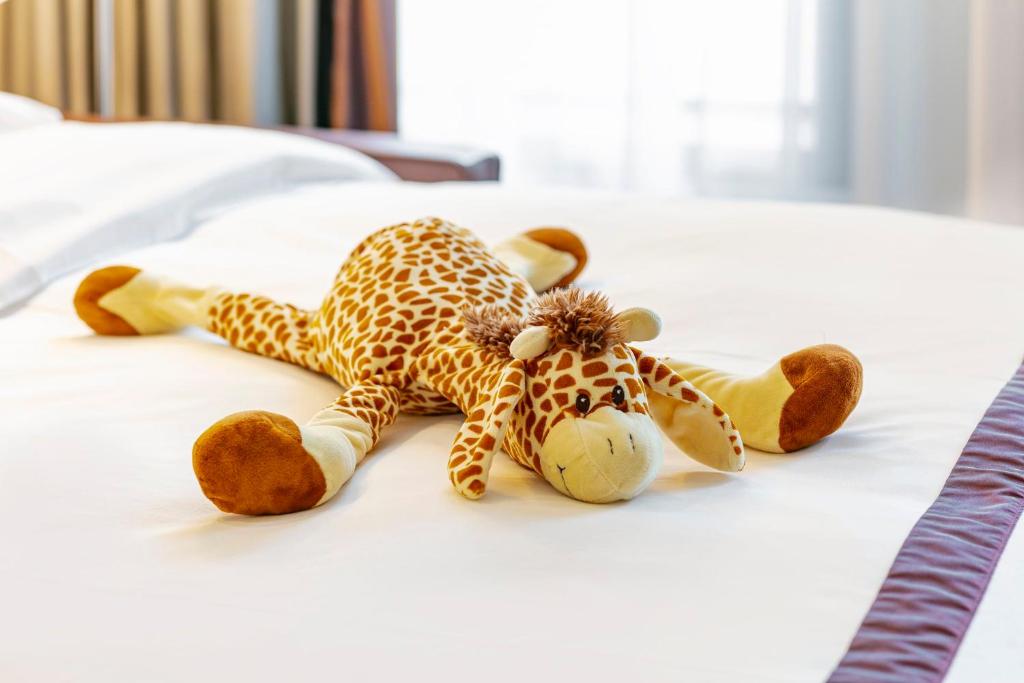 a stuffed giraffe laying on a bed at Crowne Plaza Amsterdam - South, an IHG Hotel in Amsterdam