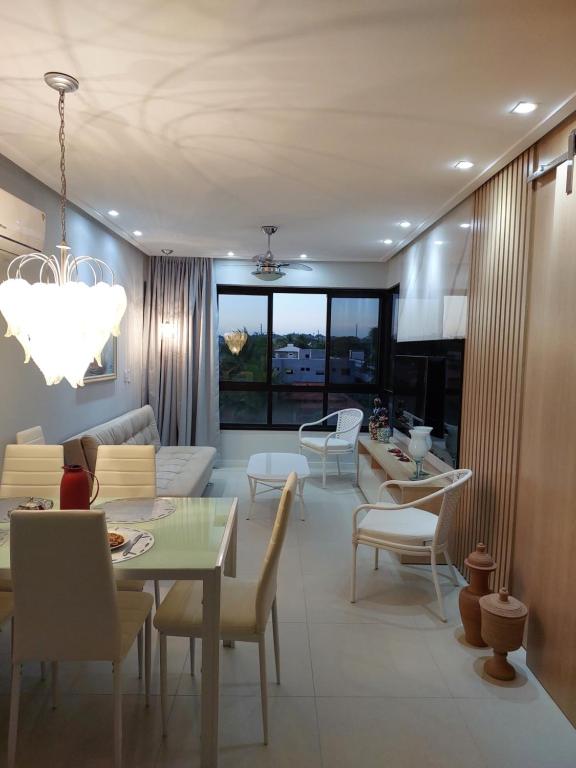 ein Wohnzimmer mit einer Couch und einem Tisch und Stühlen in der Unterkunft Guarajuba, Camaçari, Bahia, 2 quartos com suíte, cobertura, terraço in Camassari