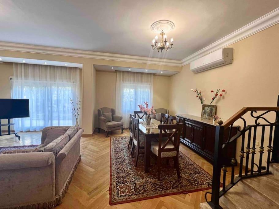 a living room with a couch and a dining room table at Elegant Villa in Sheikh Zayed City, Egypt - Families Only in Sheikh Zayed
