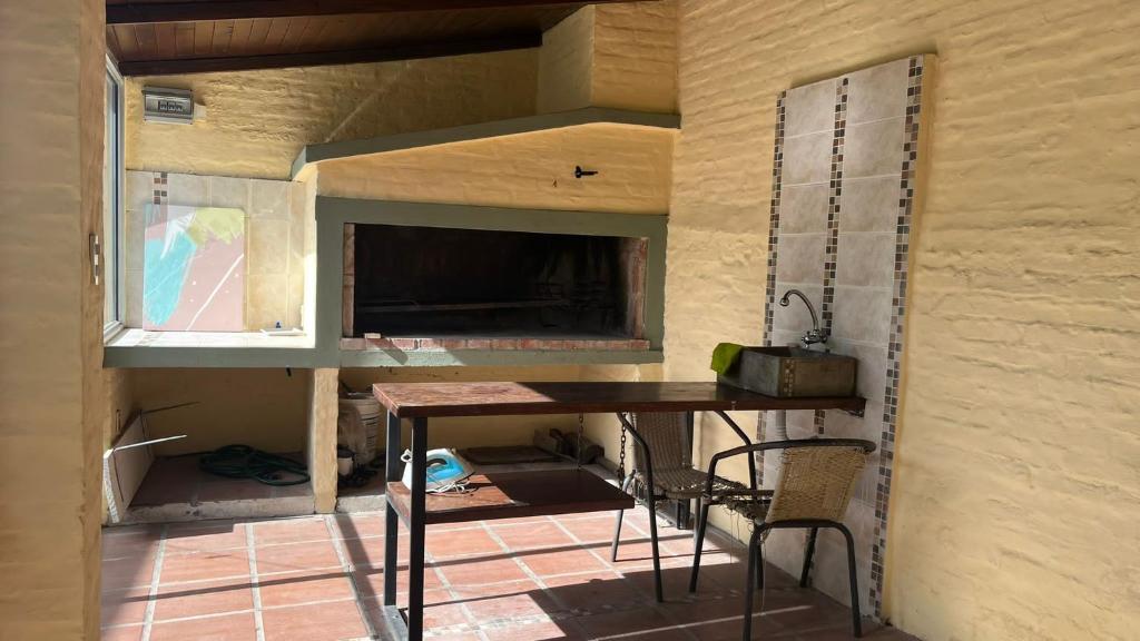 una cucina con tavolo e sedie in una stanza di Casa cabaña a Paysandú