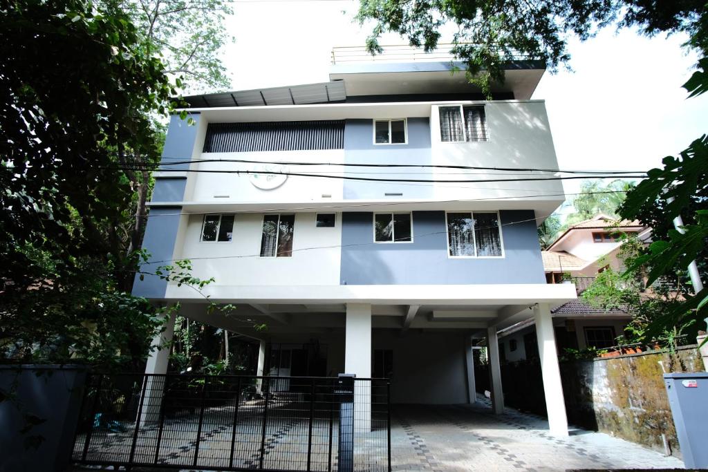 a white building with a fence in front of it at Greens in Kozhikode
