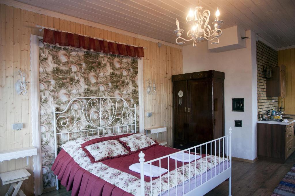 a bedroom with a bed with a red and white blanket at Lubas Apartment Monastery View in Kostroma