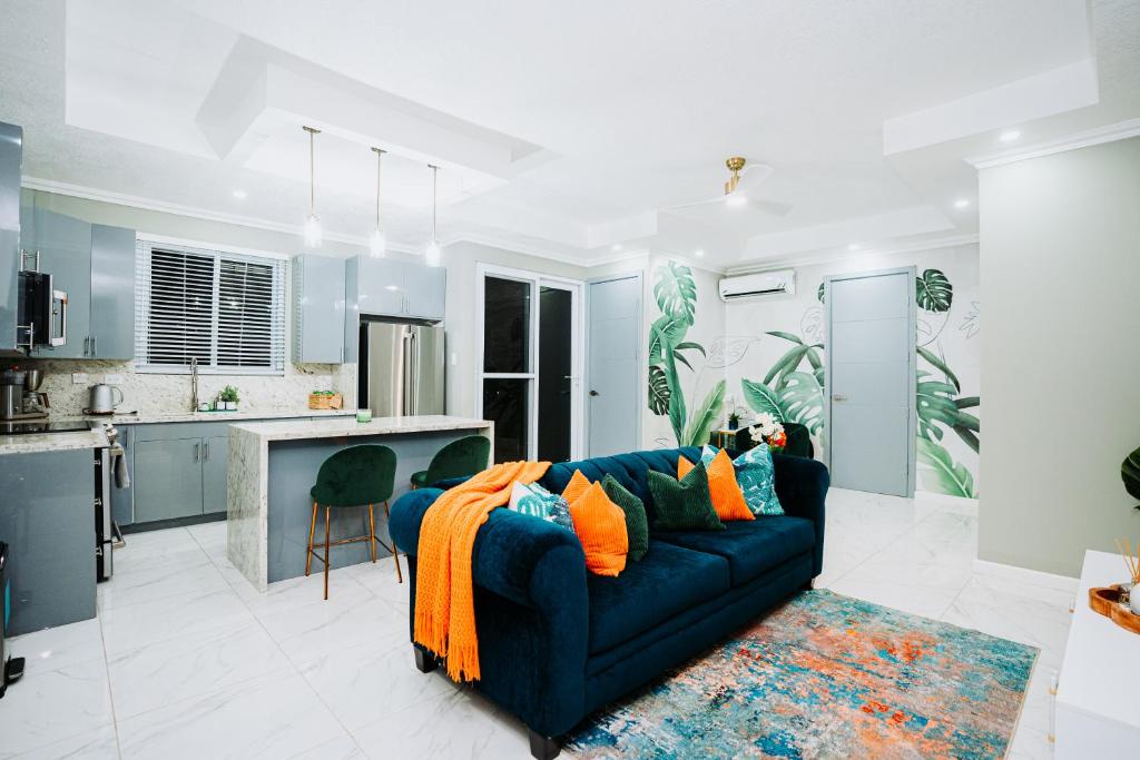 a living room with a blue couch and a kitchen at Lush Penthouse Escape with Rooftop Pool in Kingston