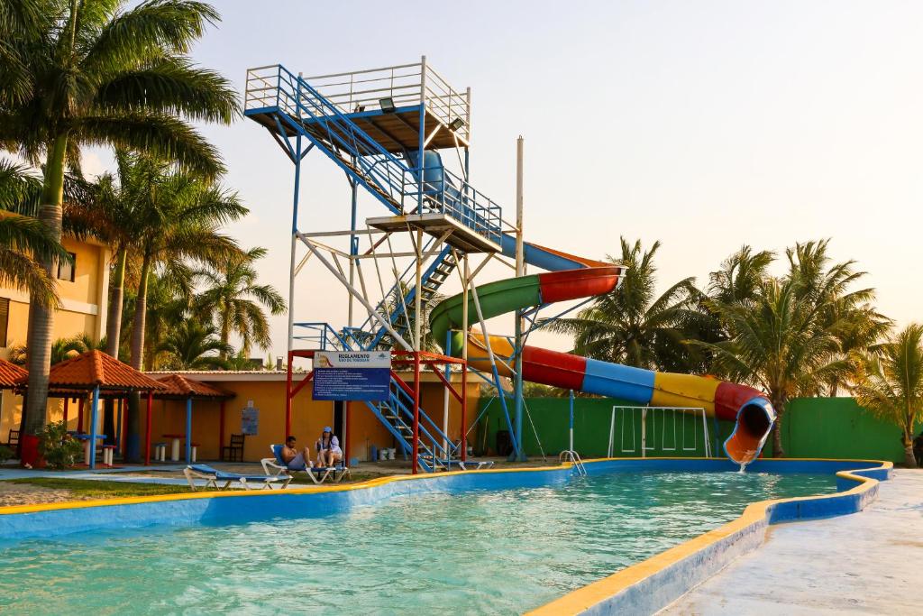 a slide in the middle of a swimming pool at Hotel Partenon Beach in La Ceiba