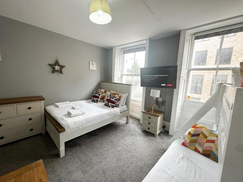 a small bedroom with two beds and a tv at Stay In Oxford Street in London