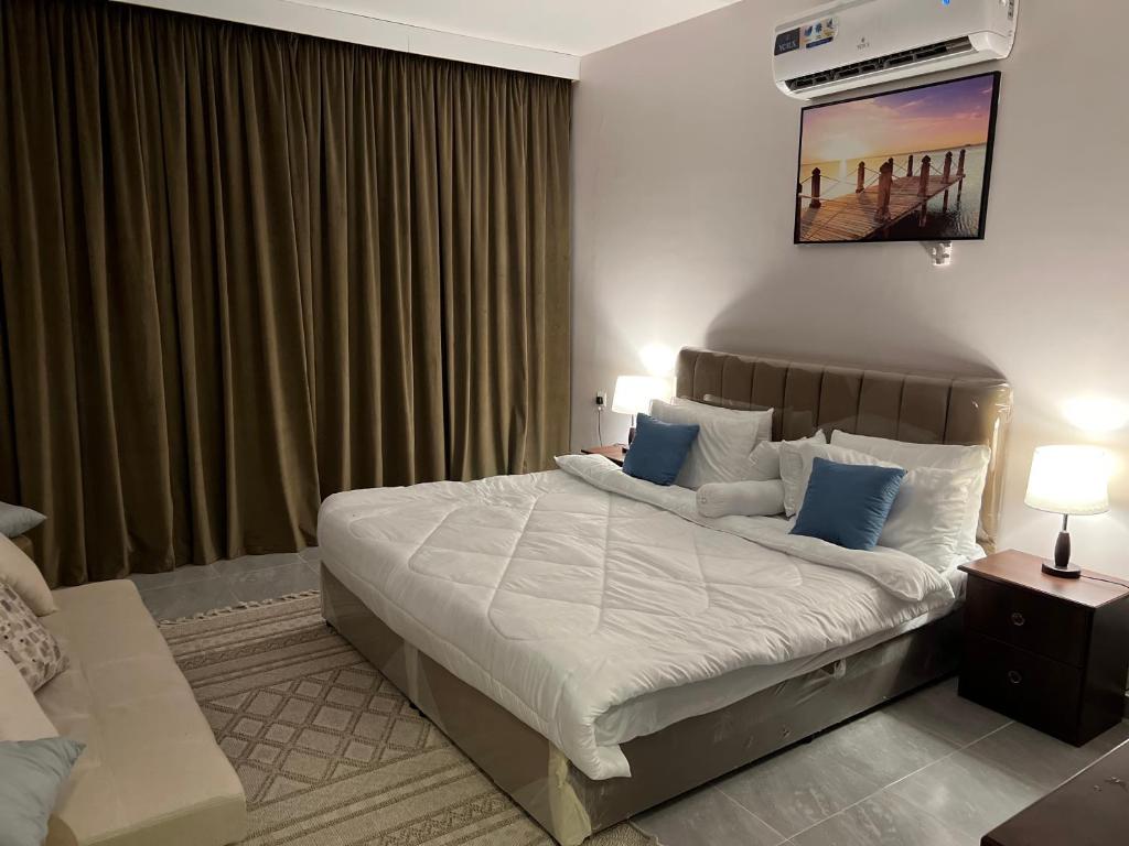 a bedroom with a large bed with blue pillows at منتجع شاطيء غوفالي GUVALI Beach شاليه طراز ميكانوس Siyal سيال سابقاً in Jeddah