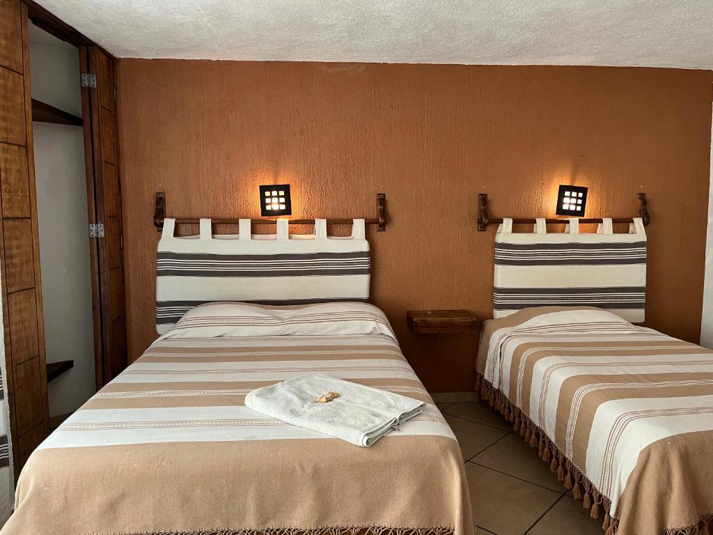 2 Betten in einem Hotelzimmer mit Handtüchern darauf in der Unterkunft Posada Verona in Huasca de Ocampo