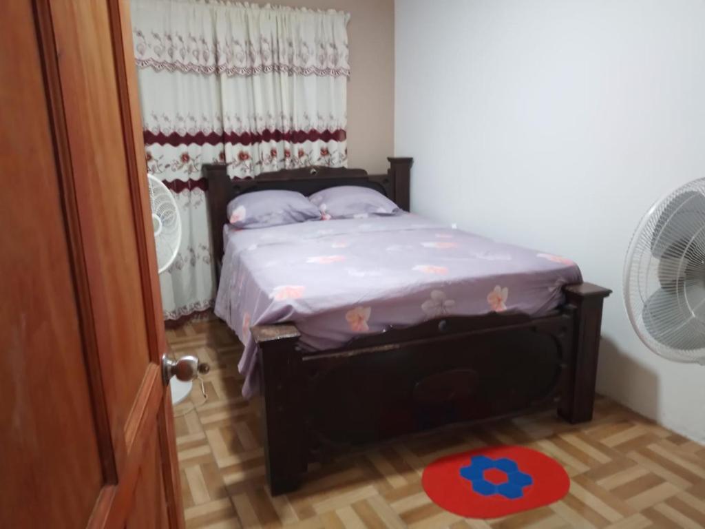 małe łóżko w pokoju z wentylatorem w obiekcie Apartamentos HJJ w mieście Puerto Limón