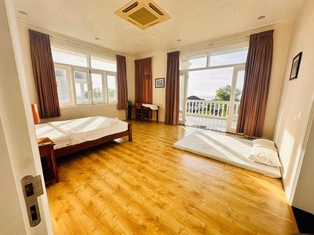 a bedroom with two beds and a wooden floor at Bougainvillea Sealinks City PC16-17-18 in Ấp Phú Tịnh (2)