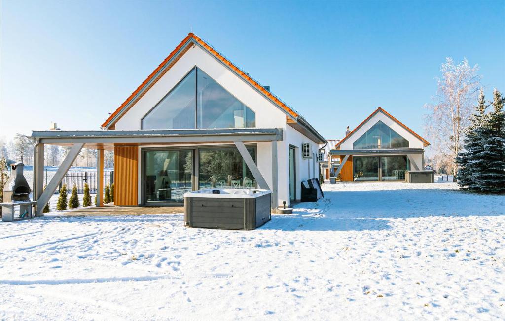 a house in the snow with a large window at Beautiful Home In Ryn With Sauna in Ryn