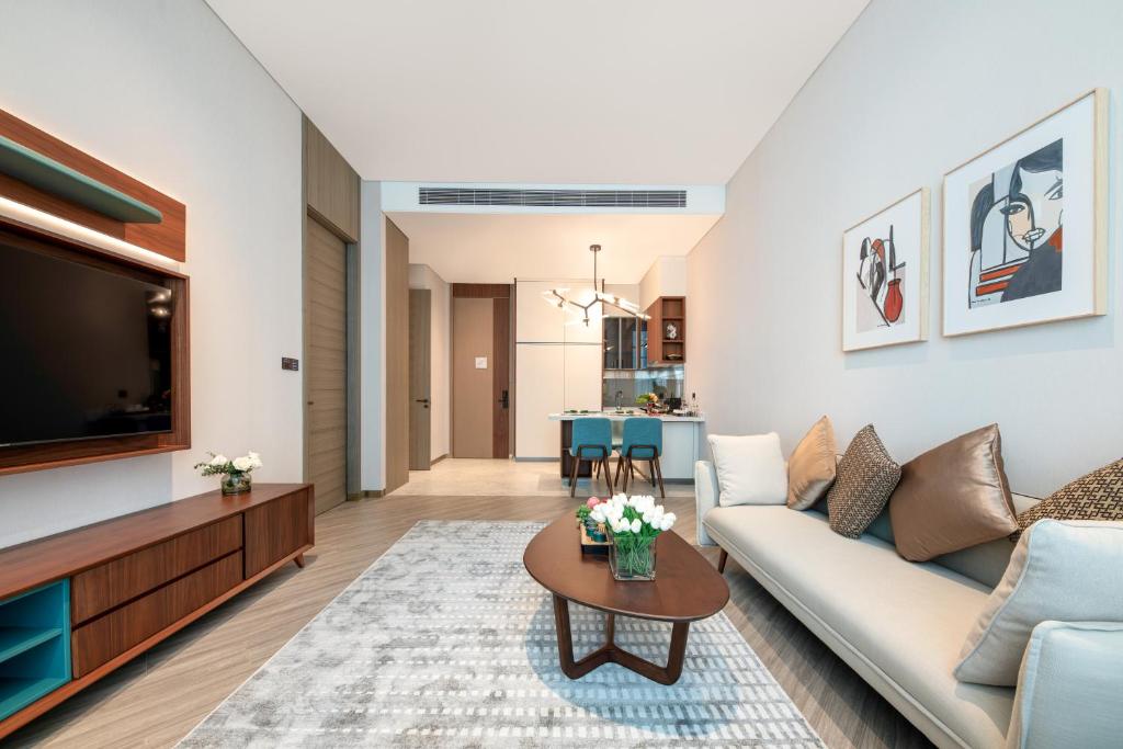 a living room with a couch and a tv at Sha Zhi Ye Serviced Apartment Hotel - Houjie Wanda Plaza Liaoxia Subway Station in Dongguan