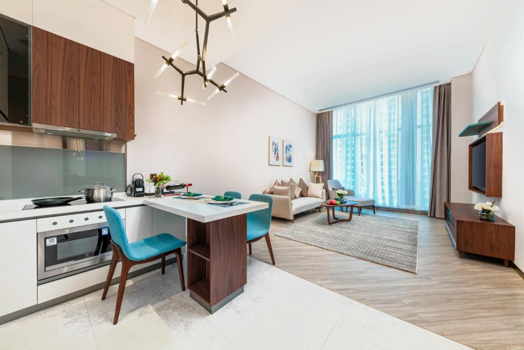 a kitchen and living room with a table and chairs at Sha Zhi Ye Serviced Apartment Hotel - Houjie Wanda Plaza Liaoxia Subway Station in Dongguan