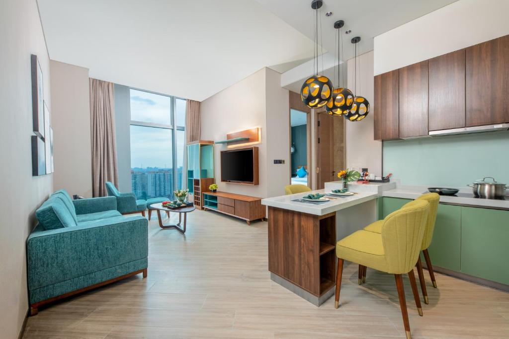 a kitchen and living room with a couch and a table at Sha Zhi Ye Serviced Apartment Hotel - Houjie Wanda Plaza Liaoxia Subway Station in Dongguan