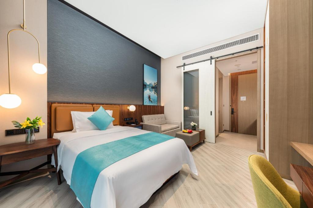 a hotel room with a large bed and a desk at Sha Zhi Ye Serviced Apartment Hotel - Houjie Wanda Plaza Liaoxia Subway Station in Dongguan