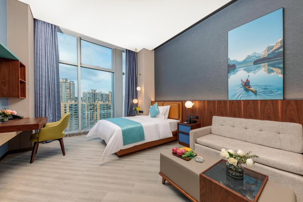 a hotel room with a bed and a couch at Sha Zhi Ye Serviced Apartment Hotel - Houjie Wanda Plaza Liaoxia Subway Station in Dongguan