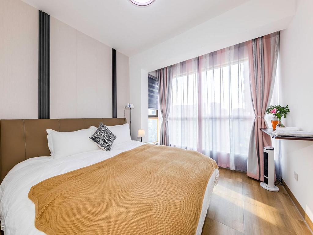 um quarto com uma cama grande e uma janela grande em Annie 公寓-2602 em Kunming