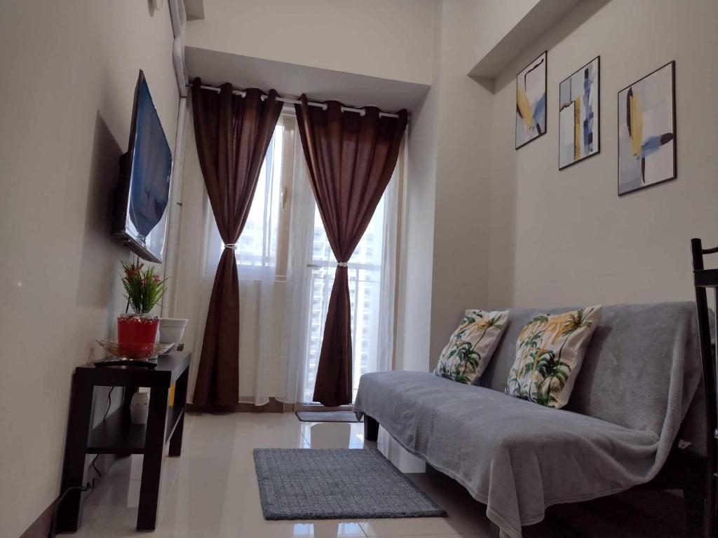 a living room with a couch and a window at G&M Comfy place for your stay at SMDC Coast Residences in Manila