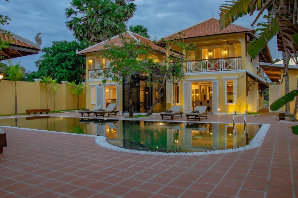 a house with a pool in front of it at Ptas Songsaa by Amatak in Siem Reap