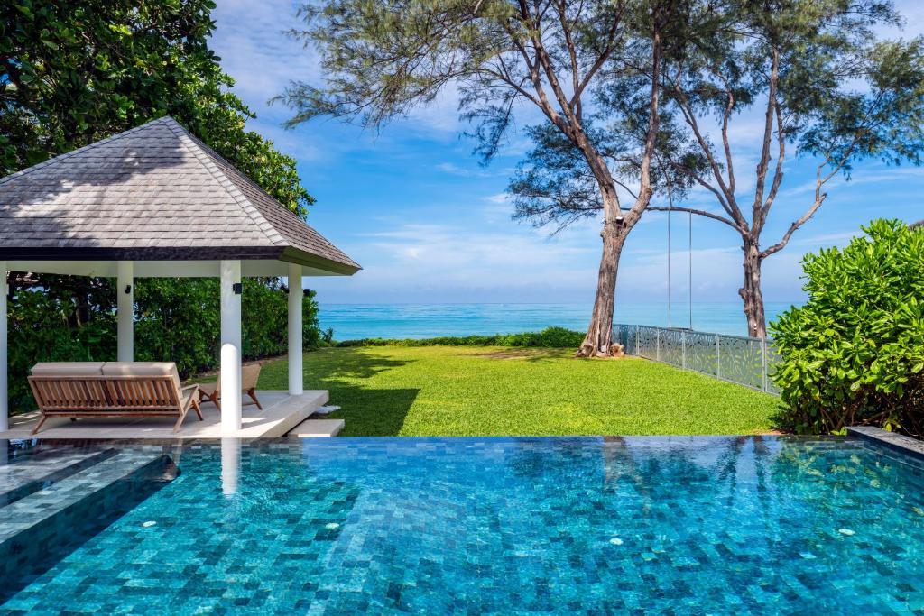 a swimming pool with a gazebo and the ocean at Twin Villas Natai South - 5 Bedroom Luxury Beach Front Villa in Natai Beach