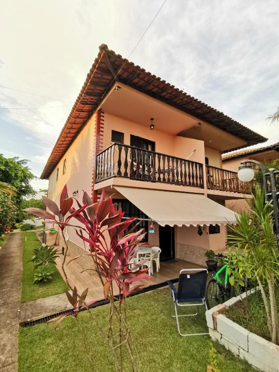 a house with a balcony and a yard at Flat Gorlaes in Araruama