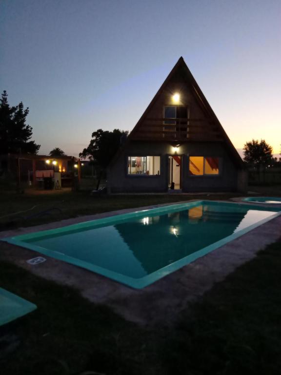 uma casa com uma piscina em frente em La Alpina em Saladillo
