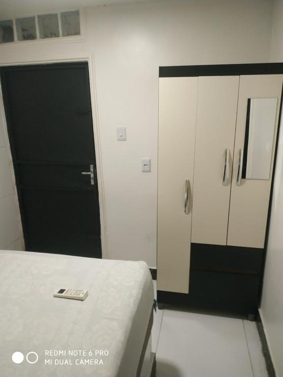 1 dormitorio con cama y puerta negra en RESIDENCIAL ESPERANÇA en Teresina