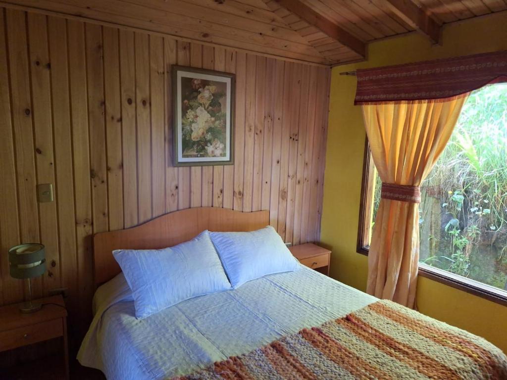 un dormitorio con una cama y una ventana en Cabaña en Castro Chiloe, en Castro