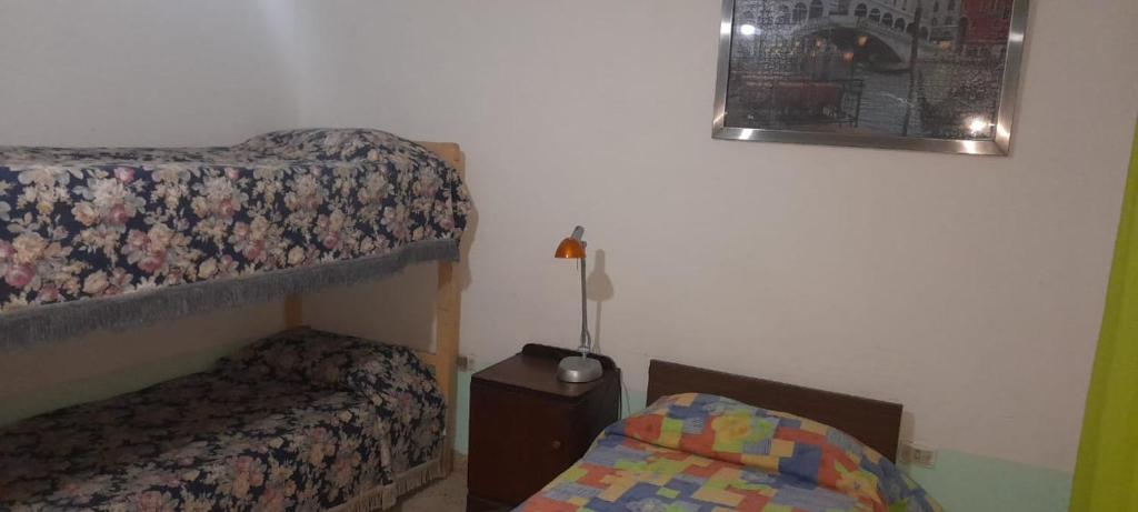 1 dormitorio con 1 litera y 1 cama pequeña en Departamentos Doña Viya en Ramallo