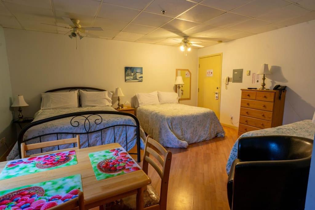 1 dormitorio con 2 camas, mesa y sillas en 224 La Beauté du Cap-de-la-Madelaine, en Trois-Rivières