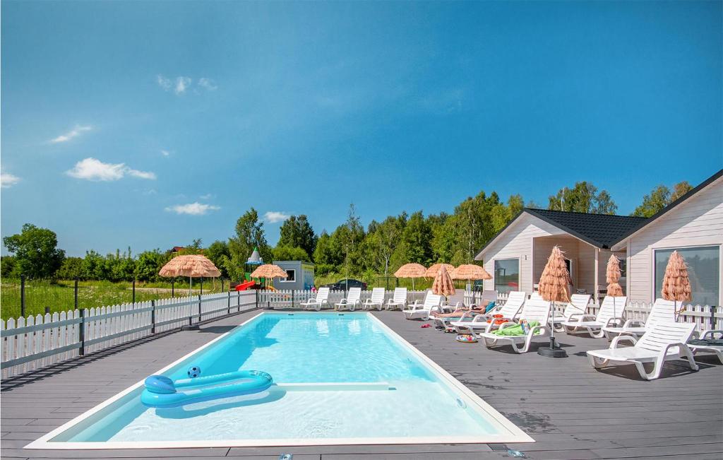 a swimming pool with chairs and umbrellas at 2 Bedroom Nice Home In Bobolin in Bobolin