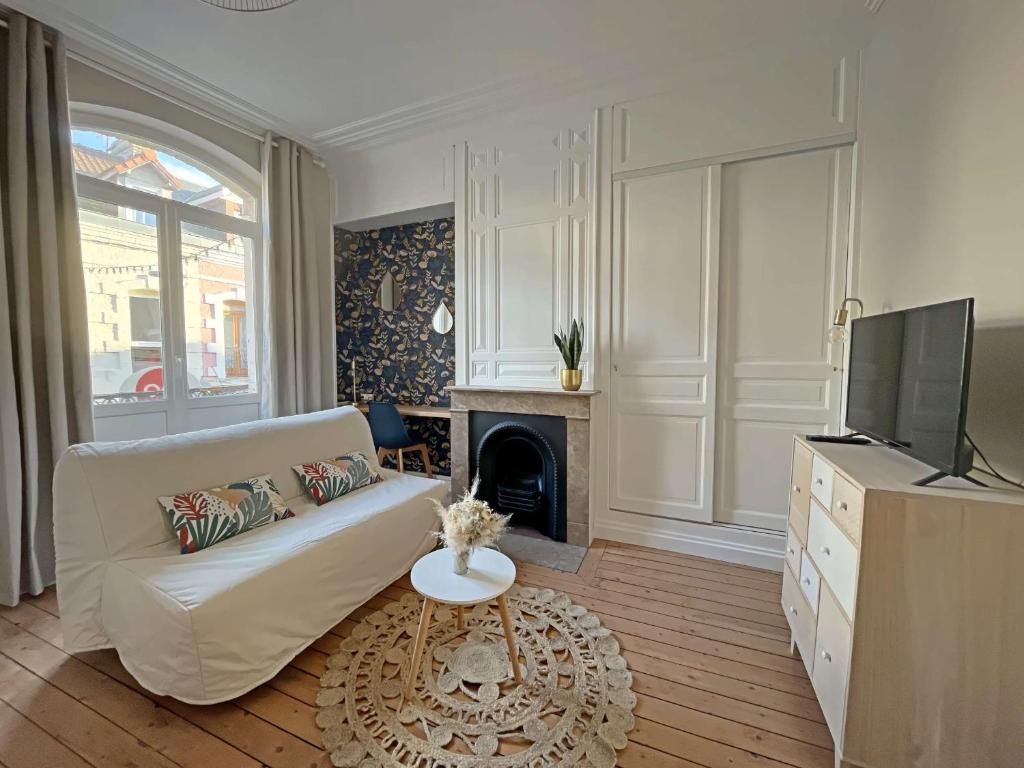 een woonkamer met een witte bank en een open haard bij Studio Berck-Plage, 1 pièce, 2 personnes - FR-1-646-57 in Berck-sur-Mer