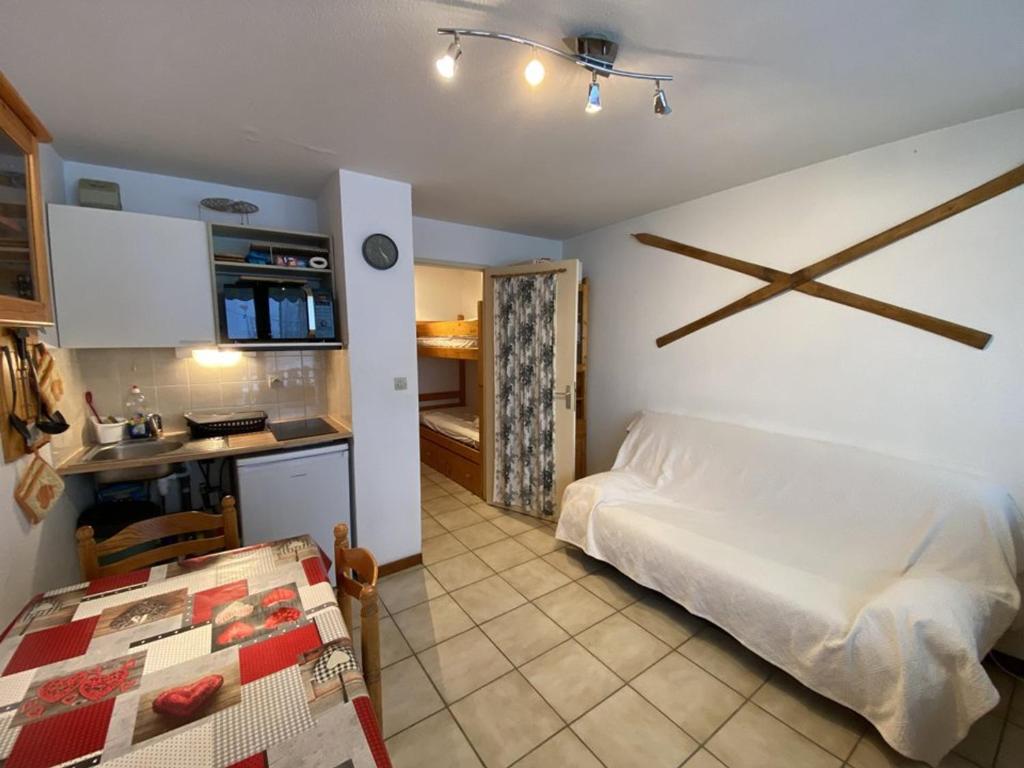 Cet appartement comprend une chambre avec un lit blanc et une cuisine. dans l'établissement Studio cosy pour 4 pers., expo Sud, près des pistes et commerces, avec balcon et équipements complets - FR-1-733-151, à Crest-Voland